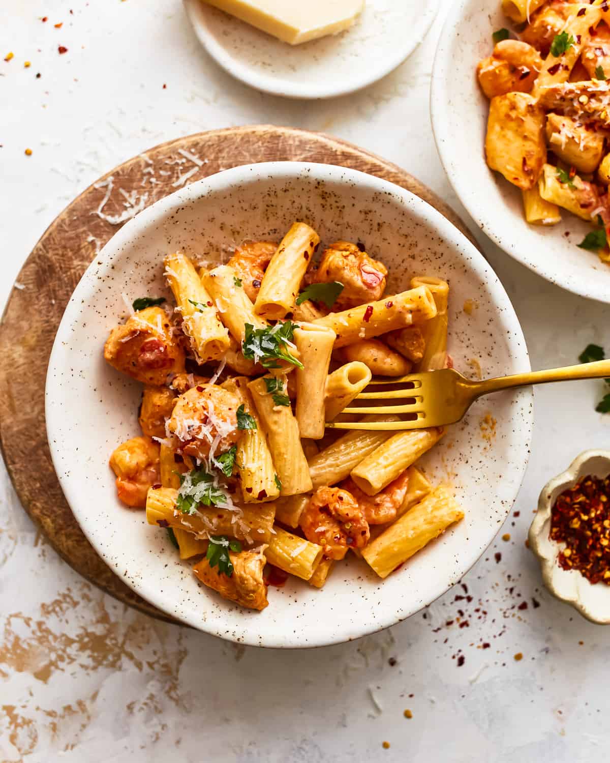 overhead view of a serving of cajun chicken pasta in a white bowl with a fork.