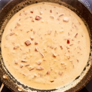 thickened creamy orange sauce in a frying pan.