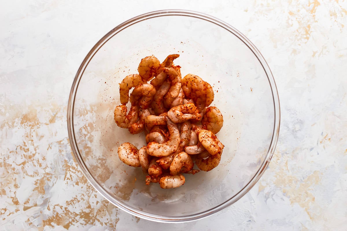 seasoned raw shrimp in a glass bowl.