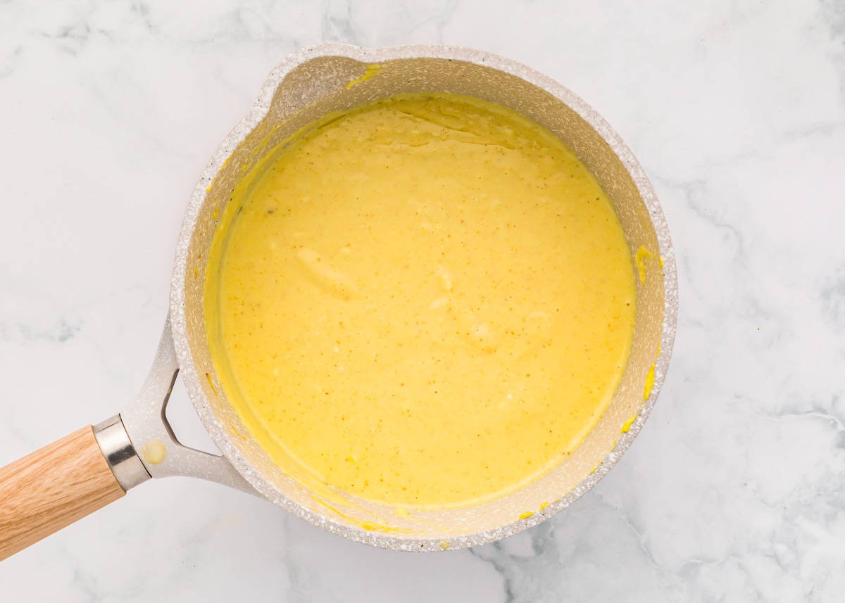 creamy yellow sauce in a saucepan.