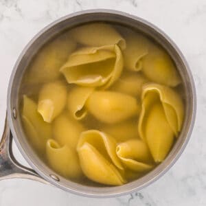 jumbo pasta shells cooking in a pot.