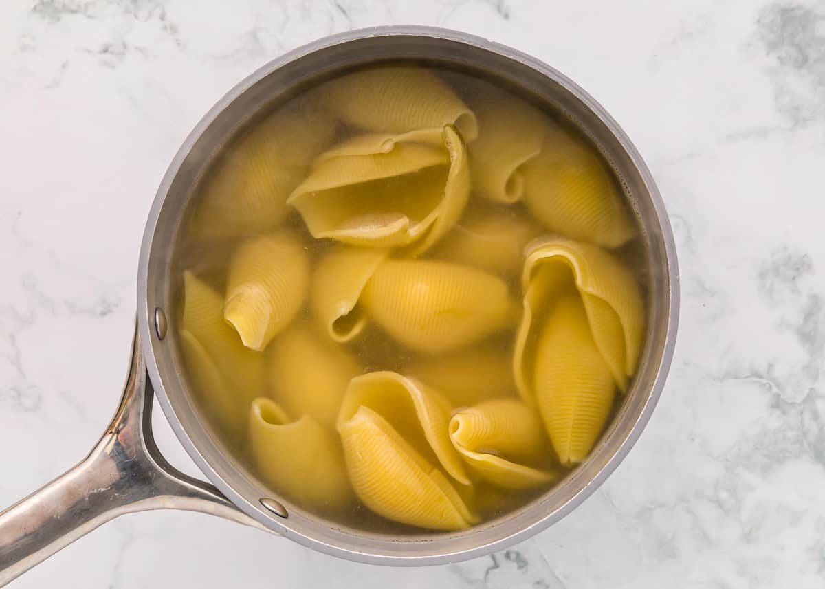 jumbo pasta shells cooking in a pot.