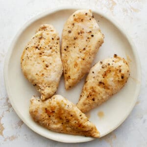 cooked chicken breasts on a white plate.