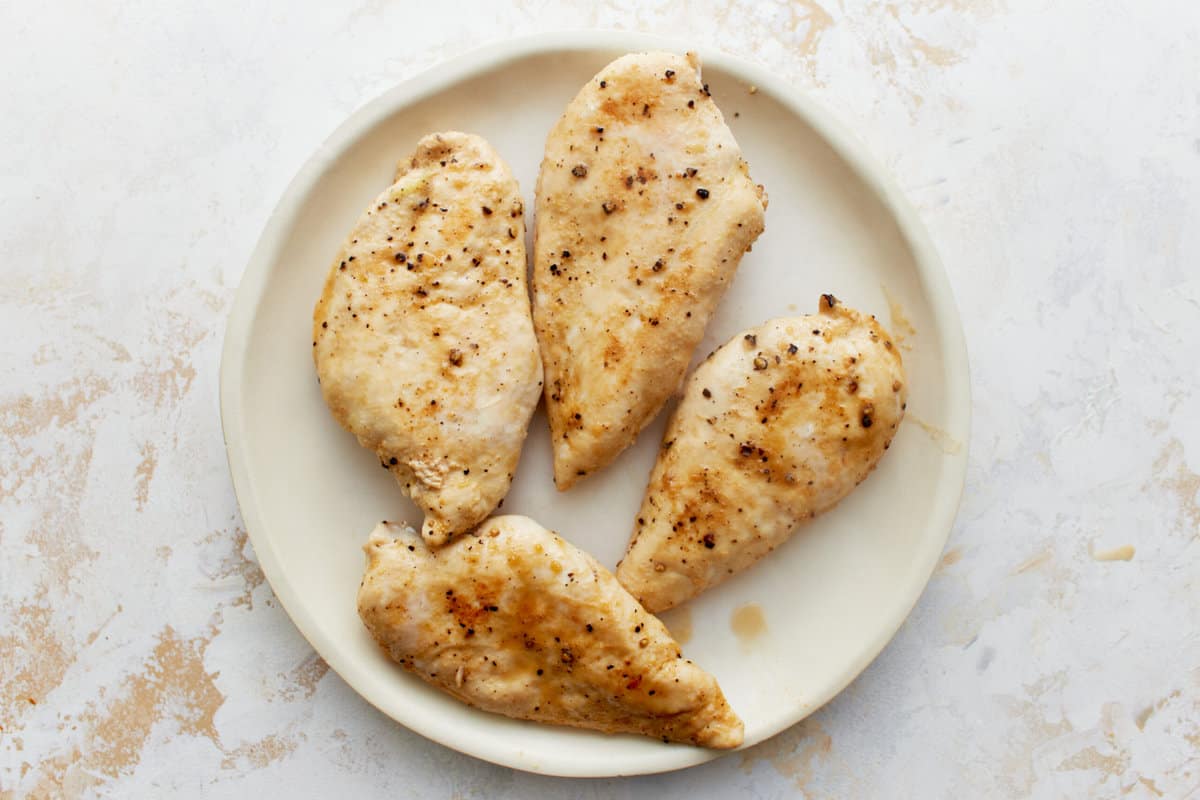 cooked chicken breasts on a white plate.