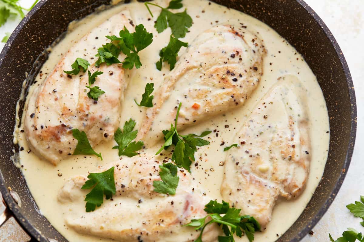 boursin chicken in a pan topped with parsley.