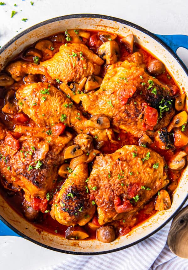 overhead view of chicken marengo in a blue pan.