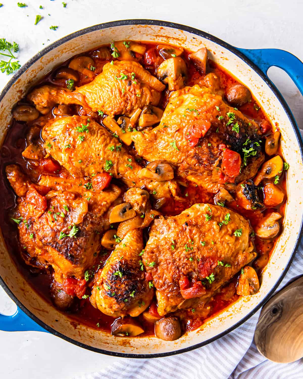 overhead view of chicken marengo in a blue pan.