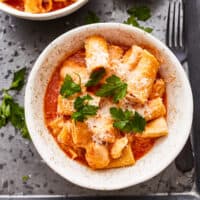 overhead view of a serving of instant pot chicken parmesan pasta in a white bowl.