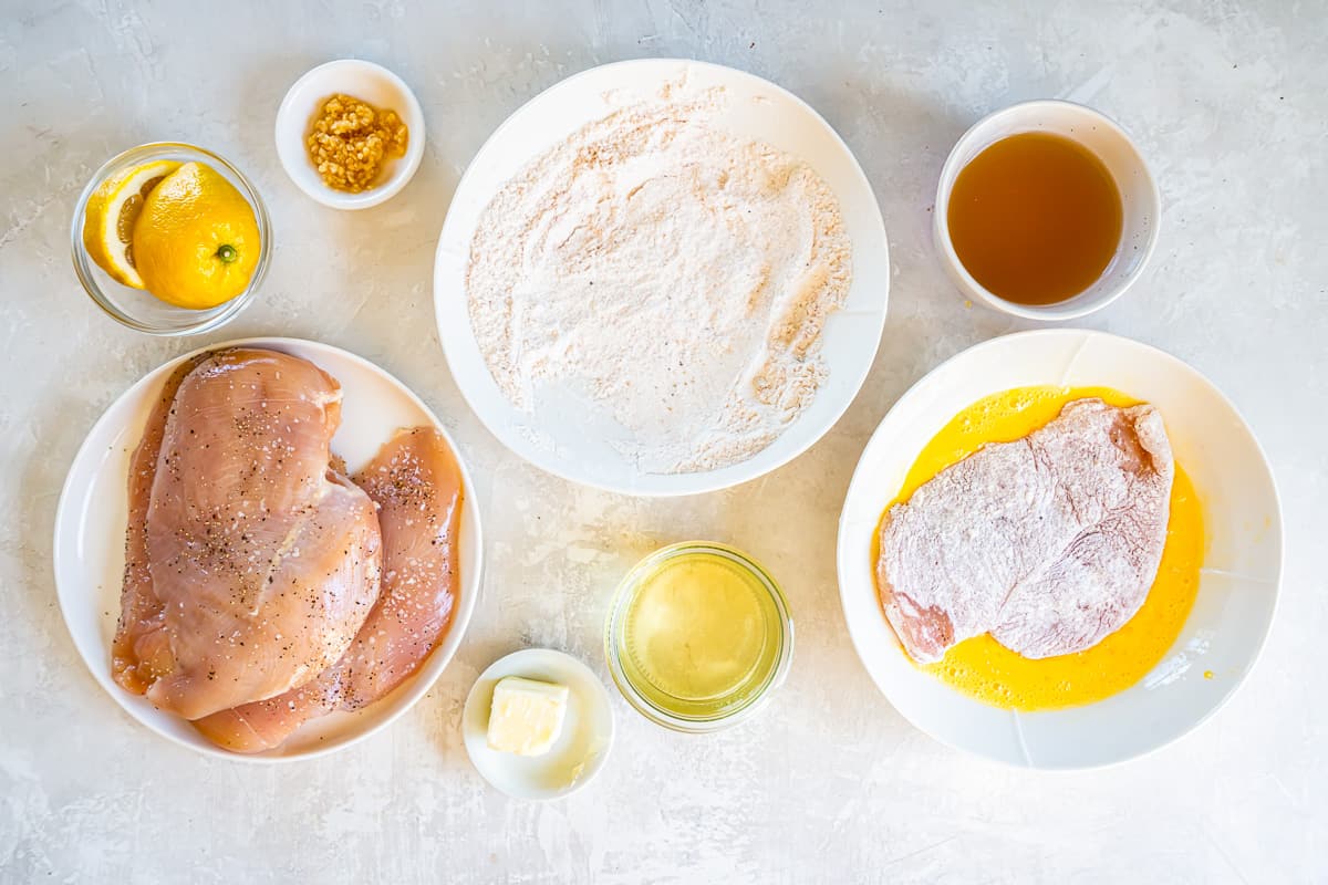 dredged chicken dipped in egg in a white bowl.