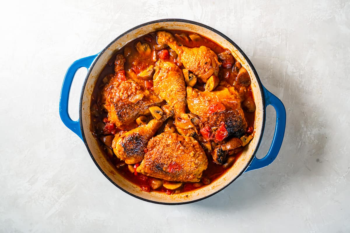 overhead view of chicken marengo in a blue pan.