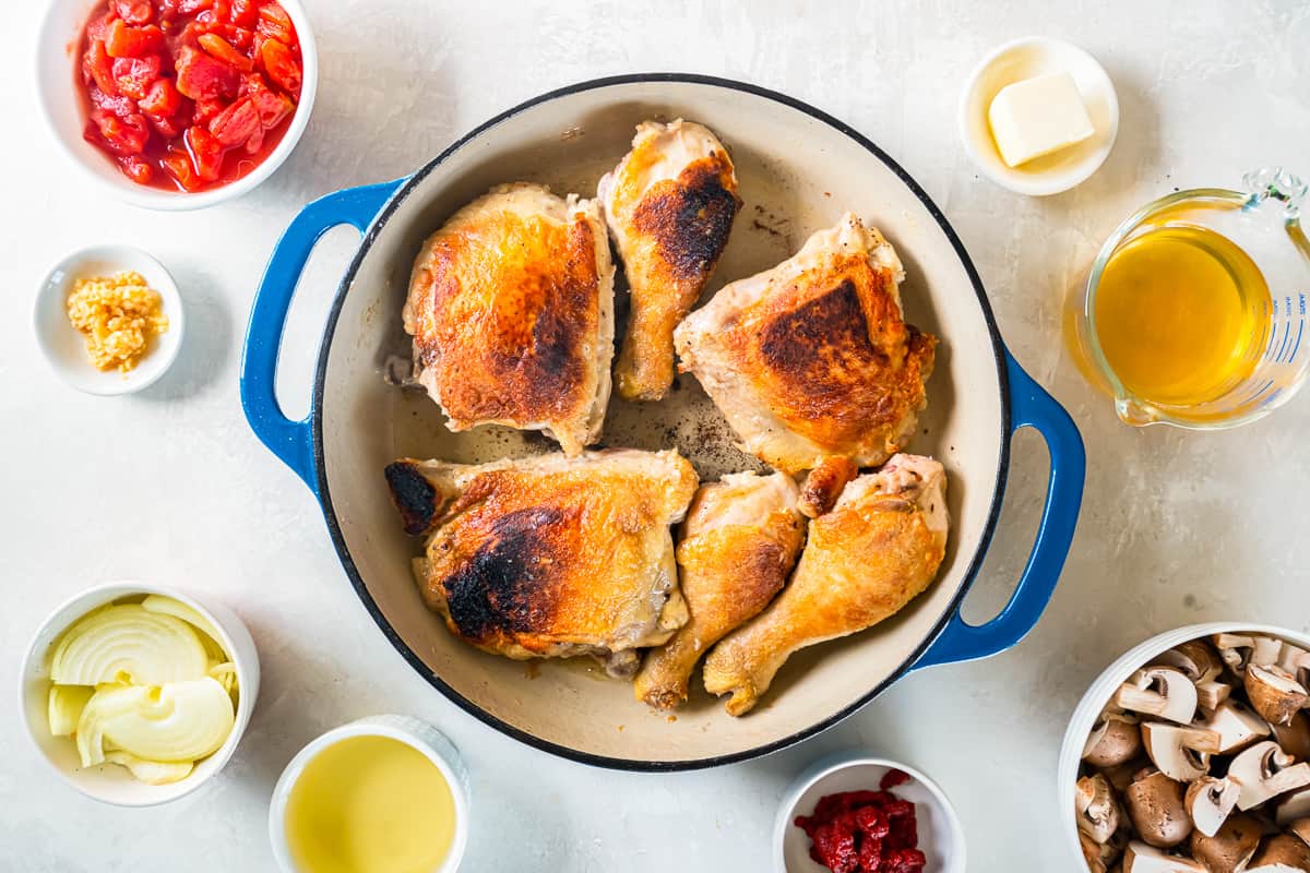 cooked chicken leg quarters in a blue pan.