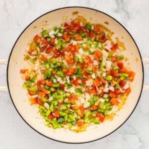 diced veggies cooking in a pan.