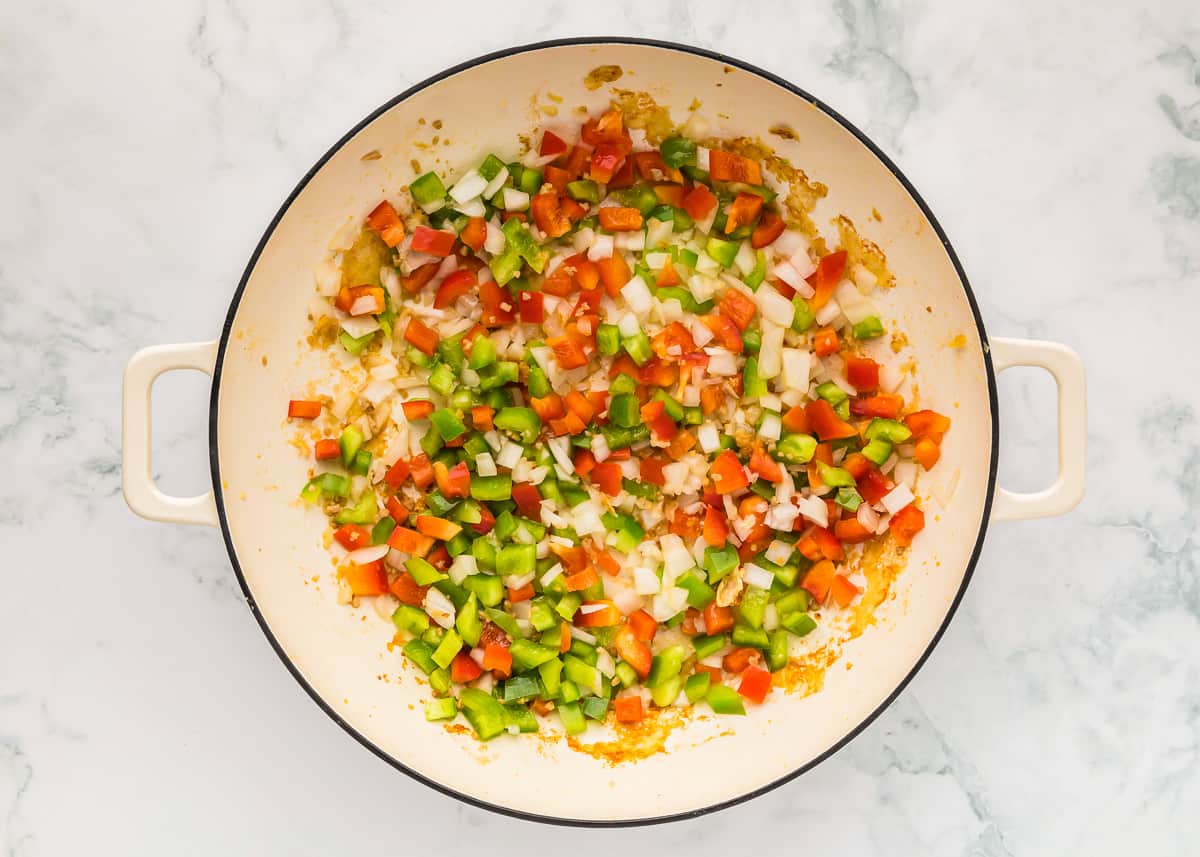 diced veggies cooking in a pan.