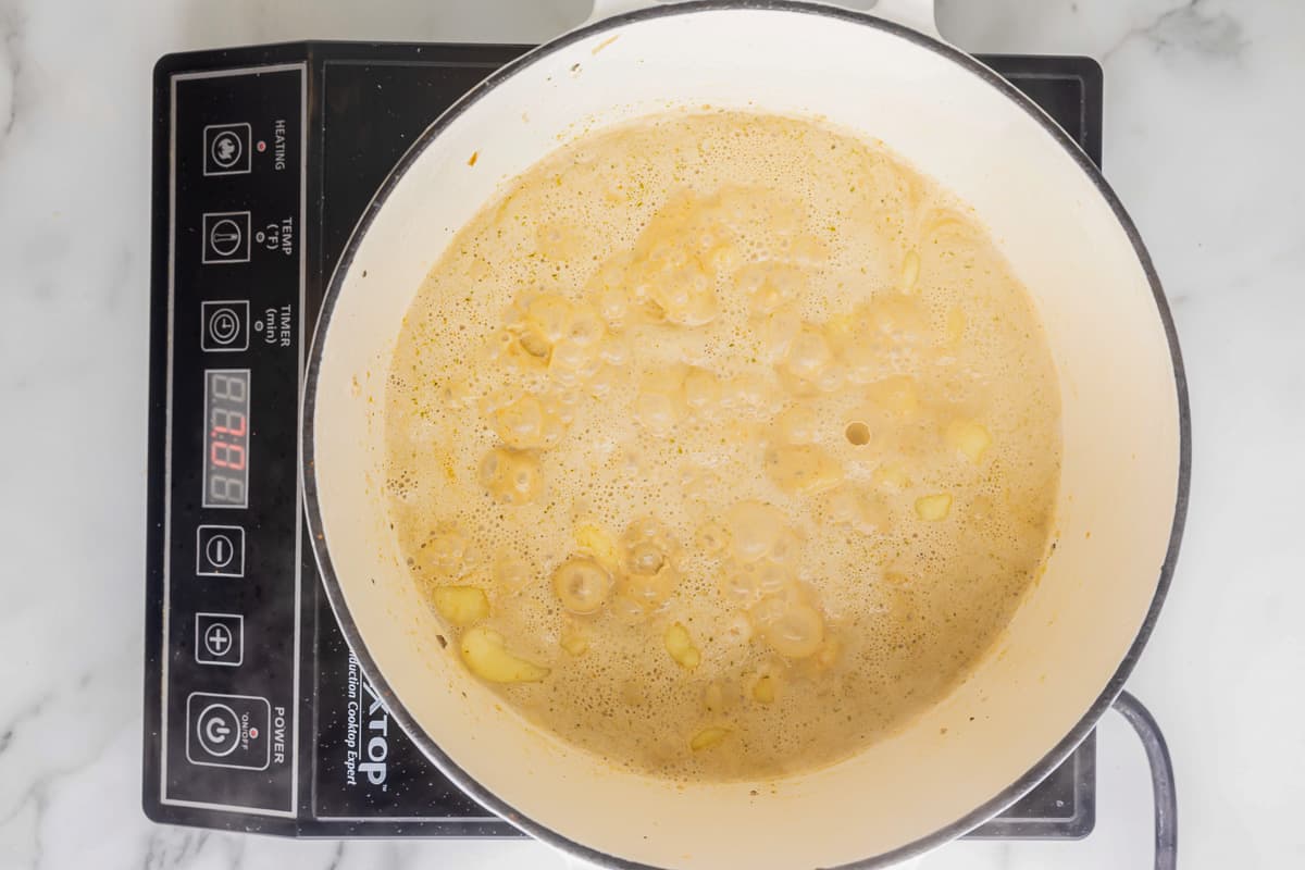 cooked gnocchi in cream sauce in a pot.