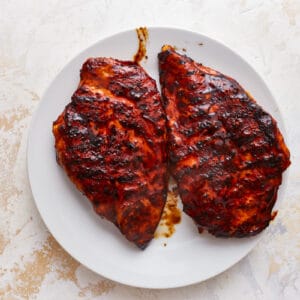 2 grilled chicken breasts on a white plate.