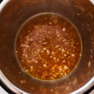 deglazing an instant pot with chicken broth.