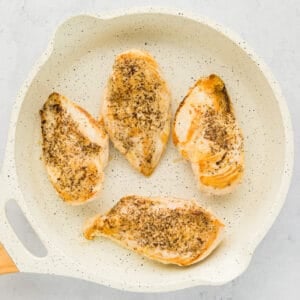 cooked chicken breasts in a white pan.