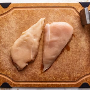 raw chicken breasts on a cutting board.