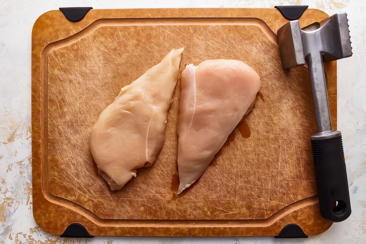 raw chicken breasts on a cutting board.