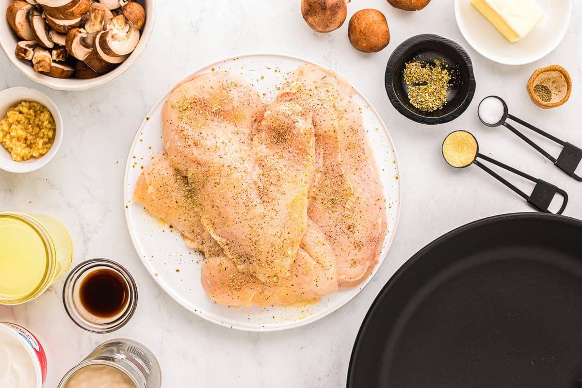 seasoned chicken breasts on a white plate.