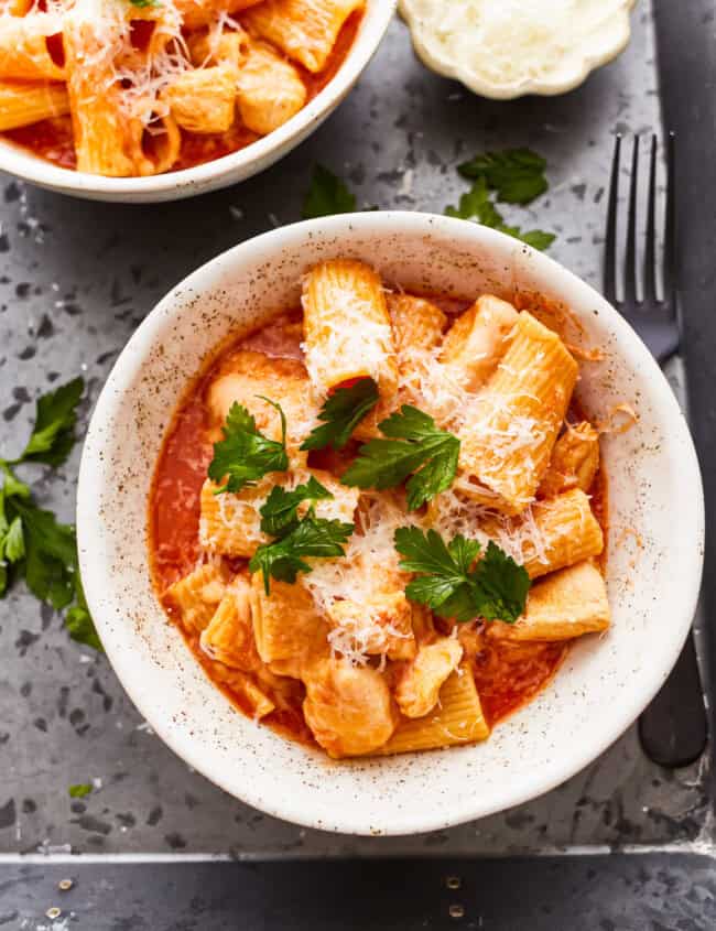 overhead view of a serving of instant pot chicken parmesan pasta in a white bowl.