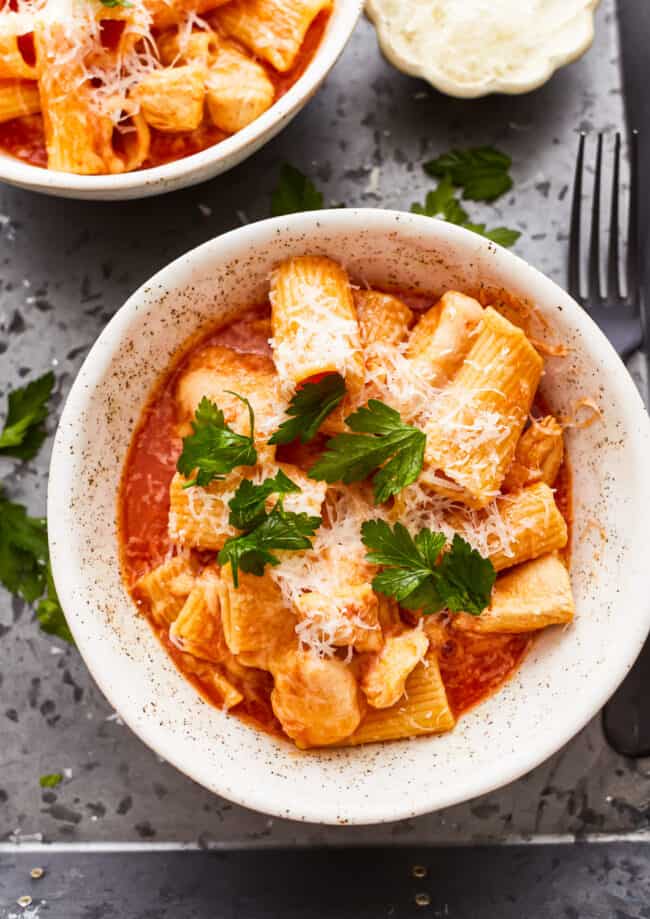 overhead view of a serving of instant pot chicken parmesan pasta in a white bowl.