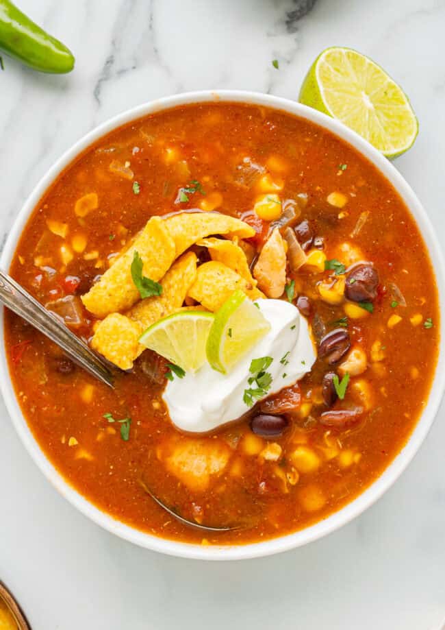 overhead view of a serving of southwest chicken soup in a bowl with a spoon.