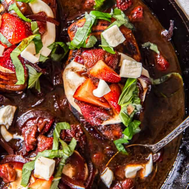 overhead view of strawberry balsamic chicken in a pan with a spoon.