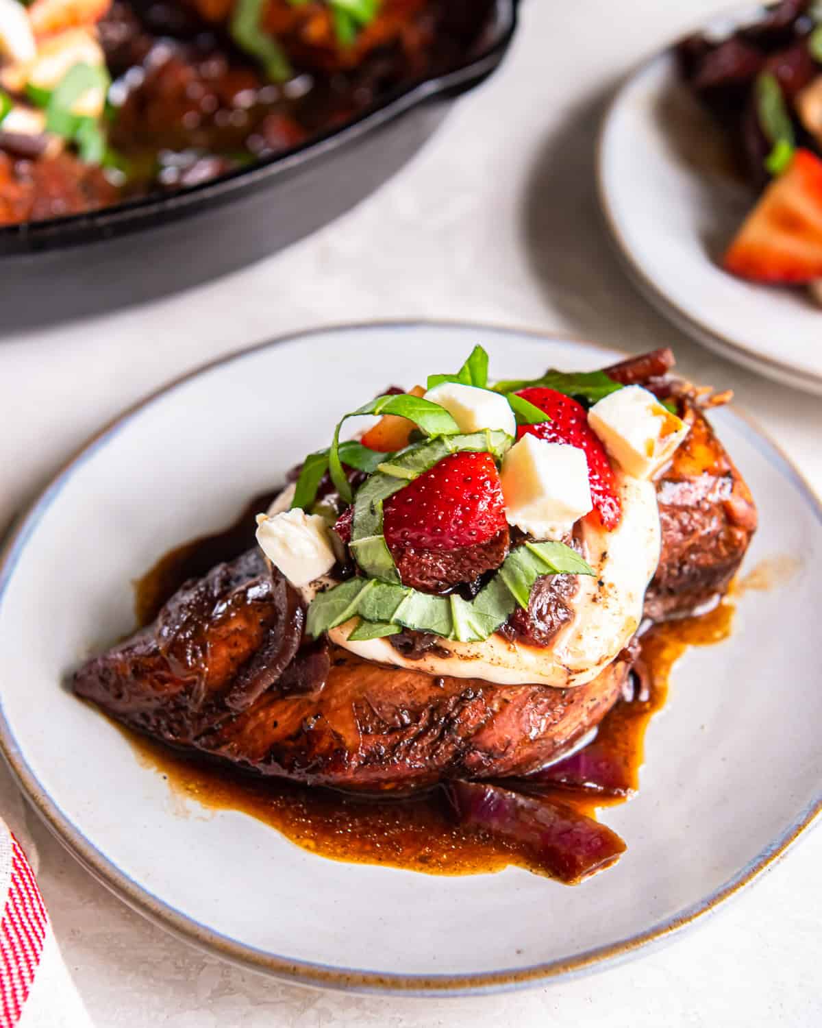 a serving of strawberry balsamic chicken on a white plate.