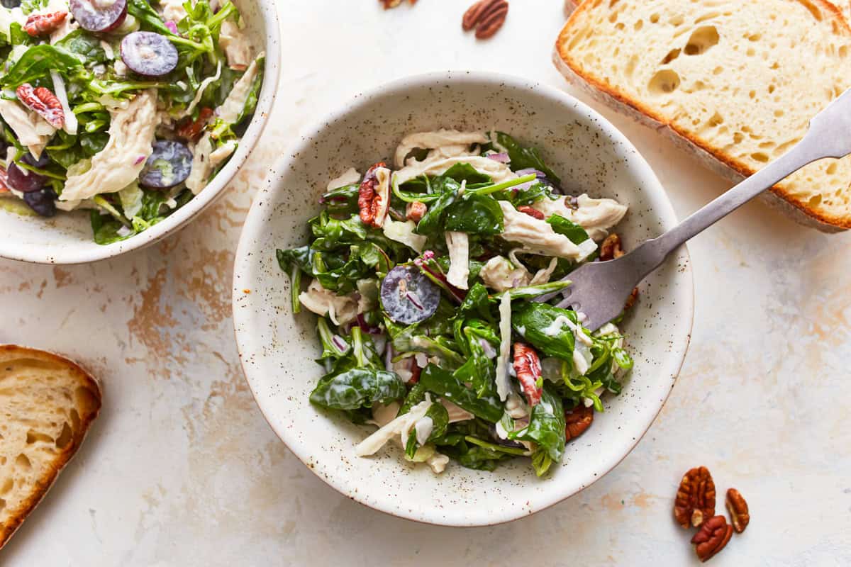 overhead view of a bowl of california chicken salad with a fork.