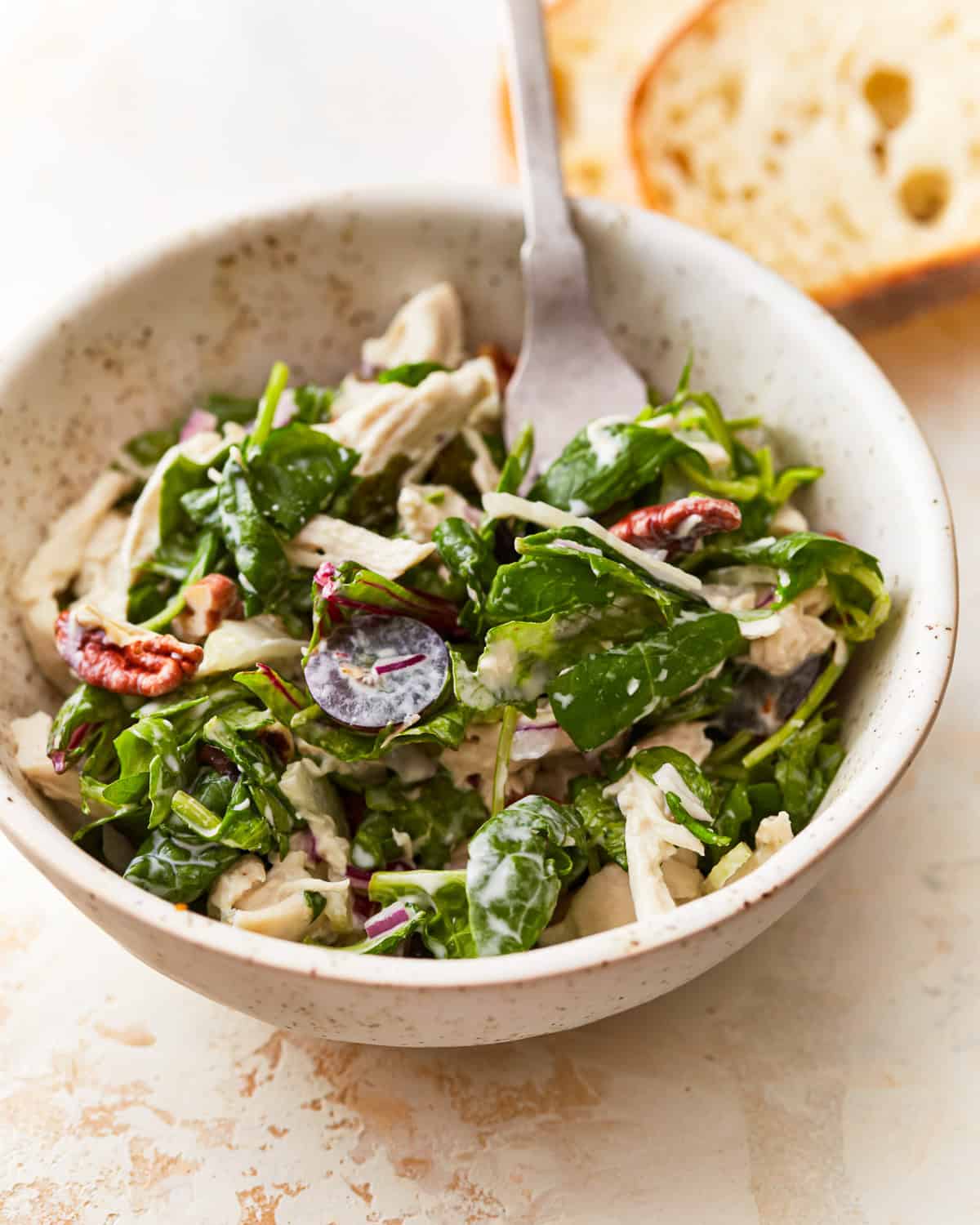 a bowl of california chicken salad with a fork.