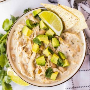 bowl of instant pot white chicken chili garnished with avocado and chips