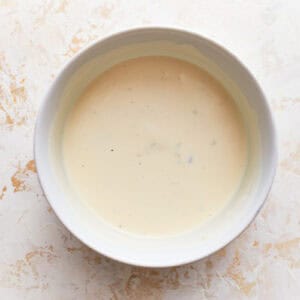 creamy dressing in a white bowl.