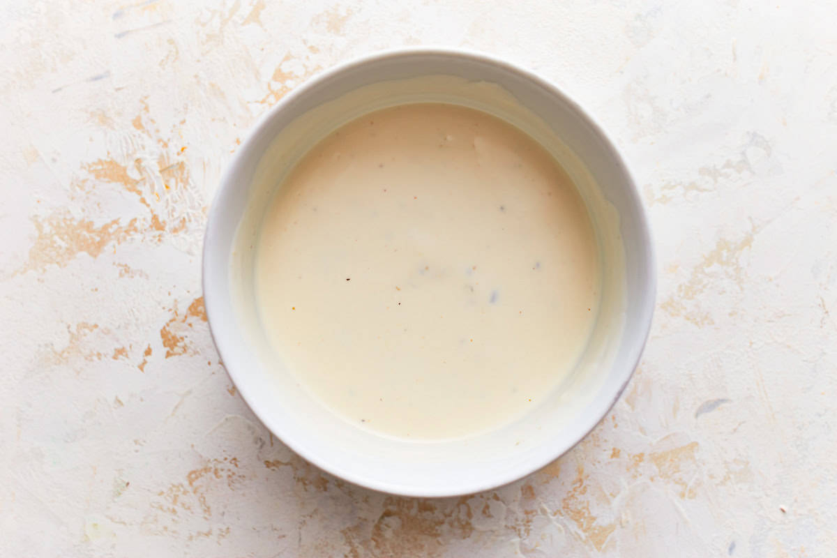 creamy dressing in a white bowl.