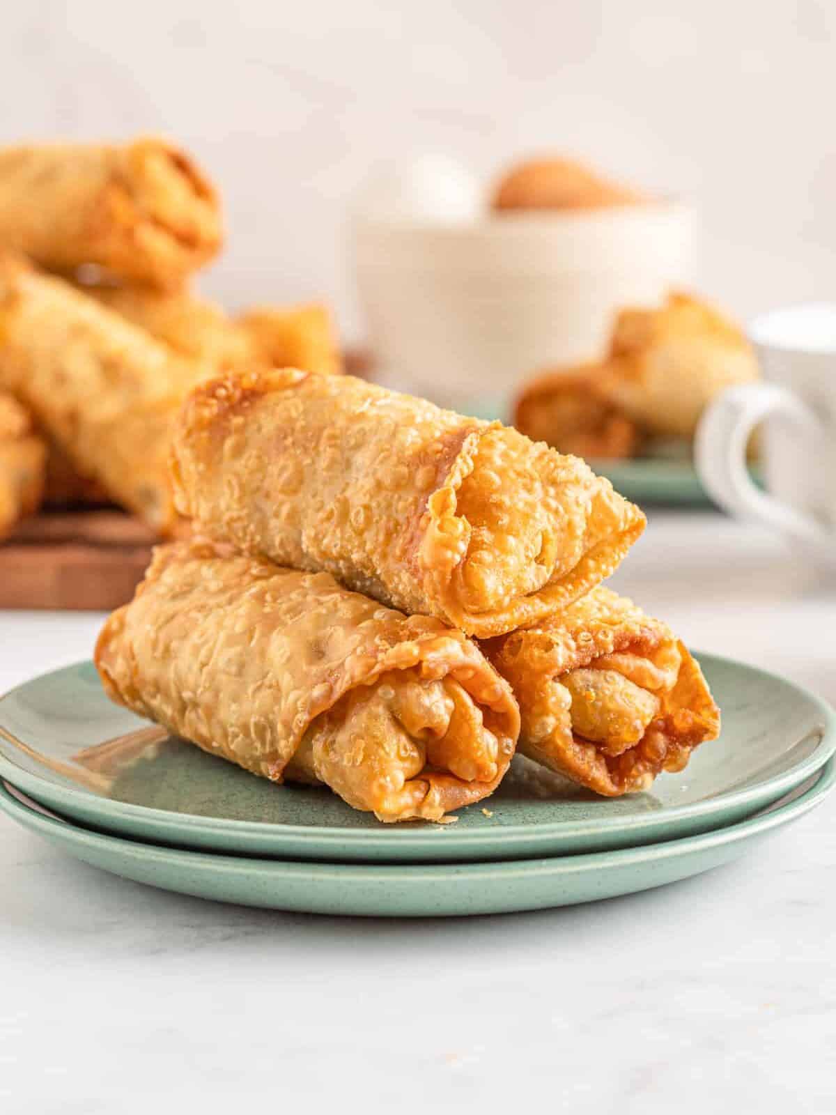 breakfast egg rolls stacked on a plate