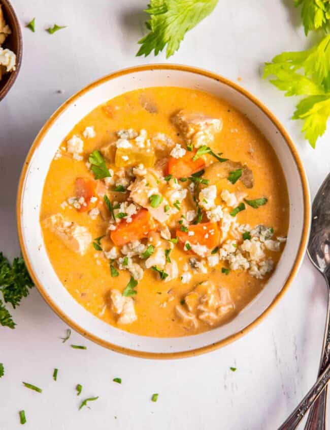 Buffalo chicken soup topped with blue cheese in a bowl