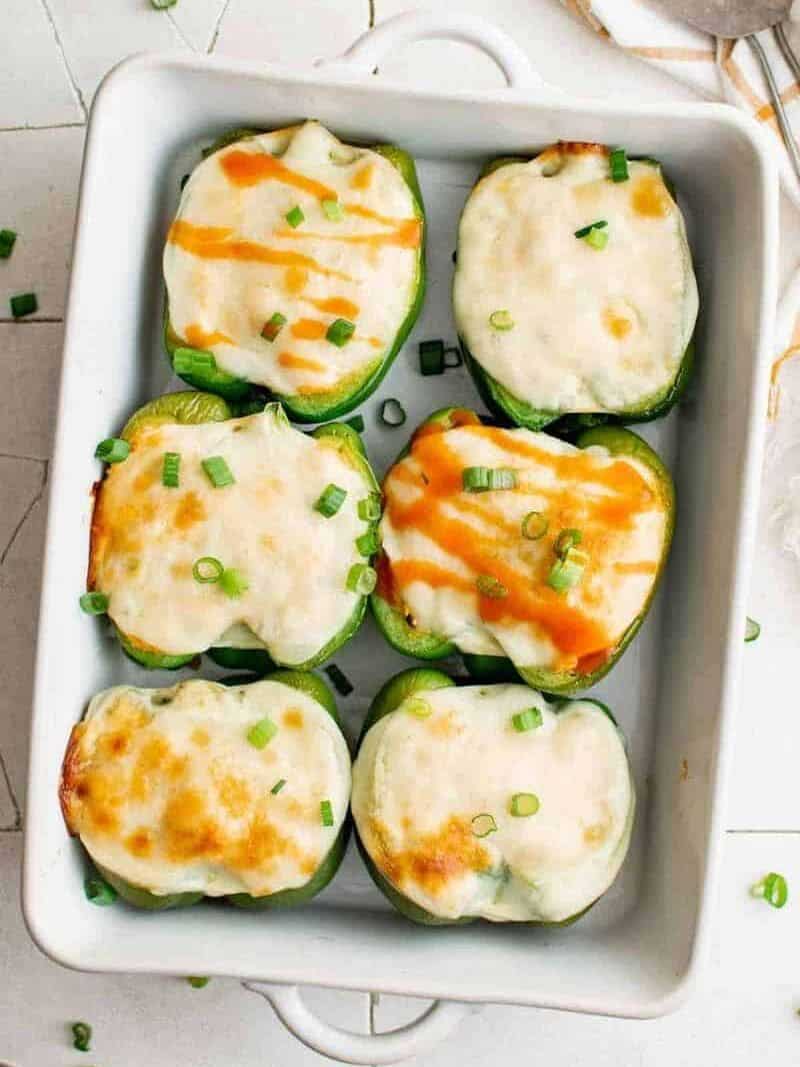 buffalo chicken stuffed peppers in a white baking dish after baking