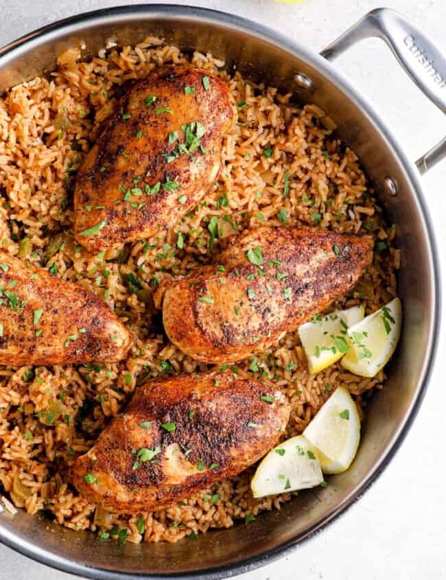 overhead image of cajun chicken breasts on top of rice in a skillet