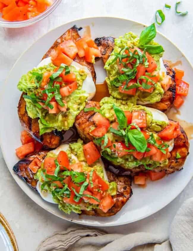 overhead view of 3 california grilled chicken breasts on a white plate.