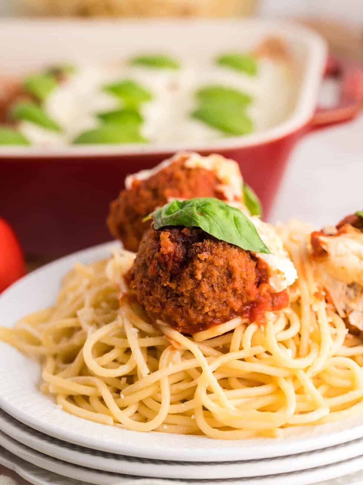 spaghetti noodles topped with 2 chicken parmesan meatballs