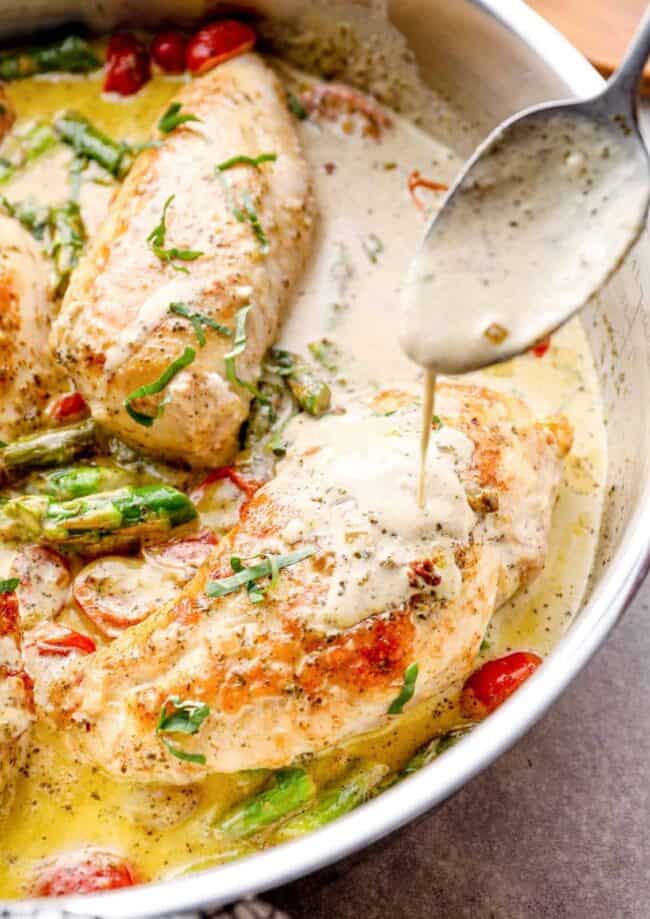 spoon drizzling sauce onto chicken breast in a skillet