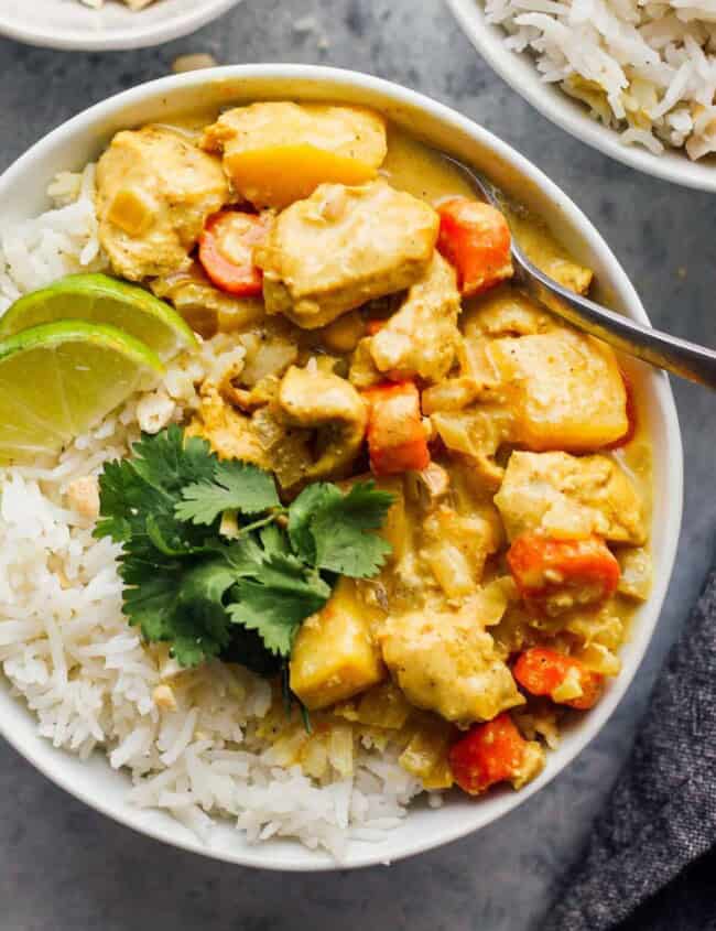 crockpot yellow chicken curry with rice in white bowl