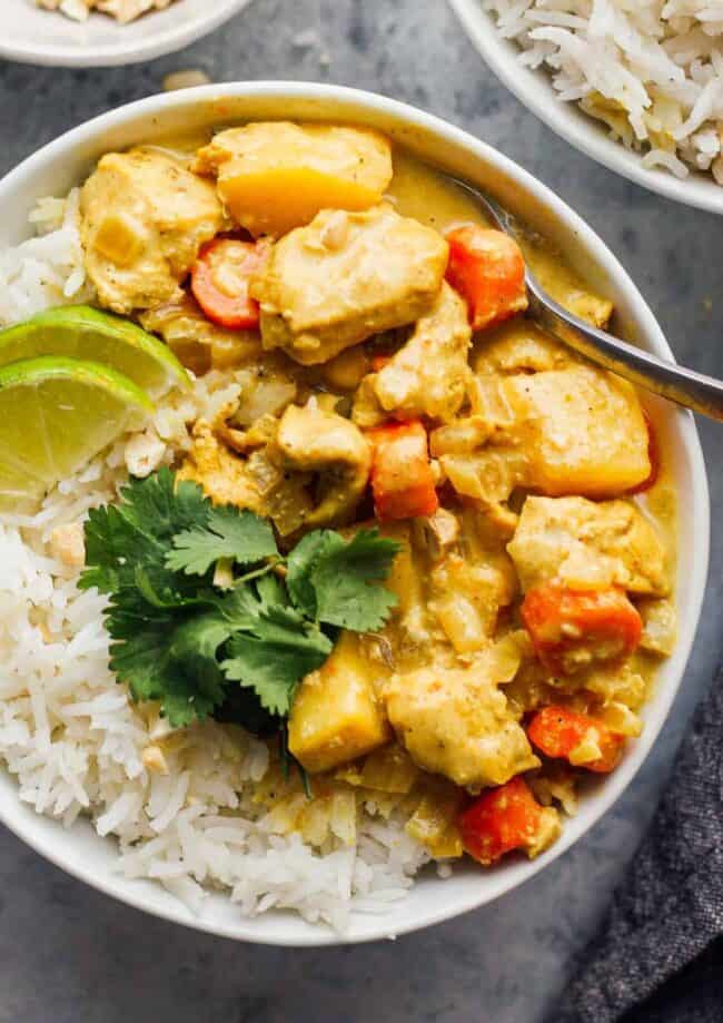 crockpot yellow chicken curry with rice in white bowl