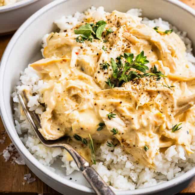 A bowl of shredded Italian dressing chicken served over white rice.