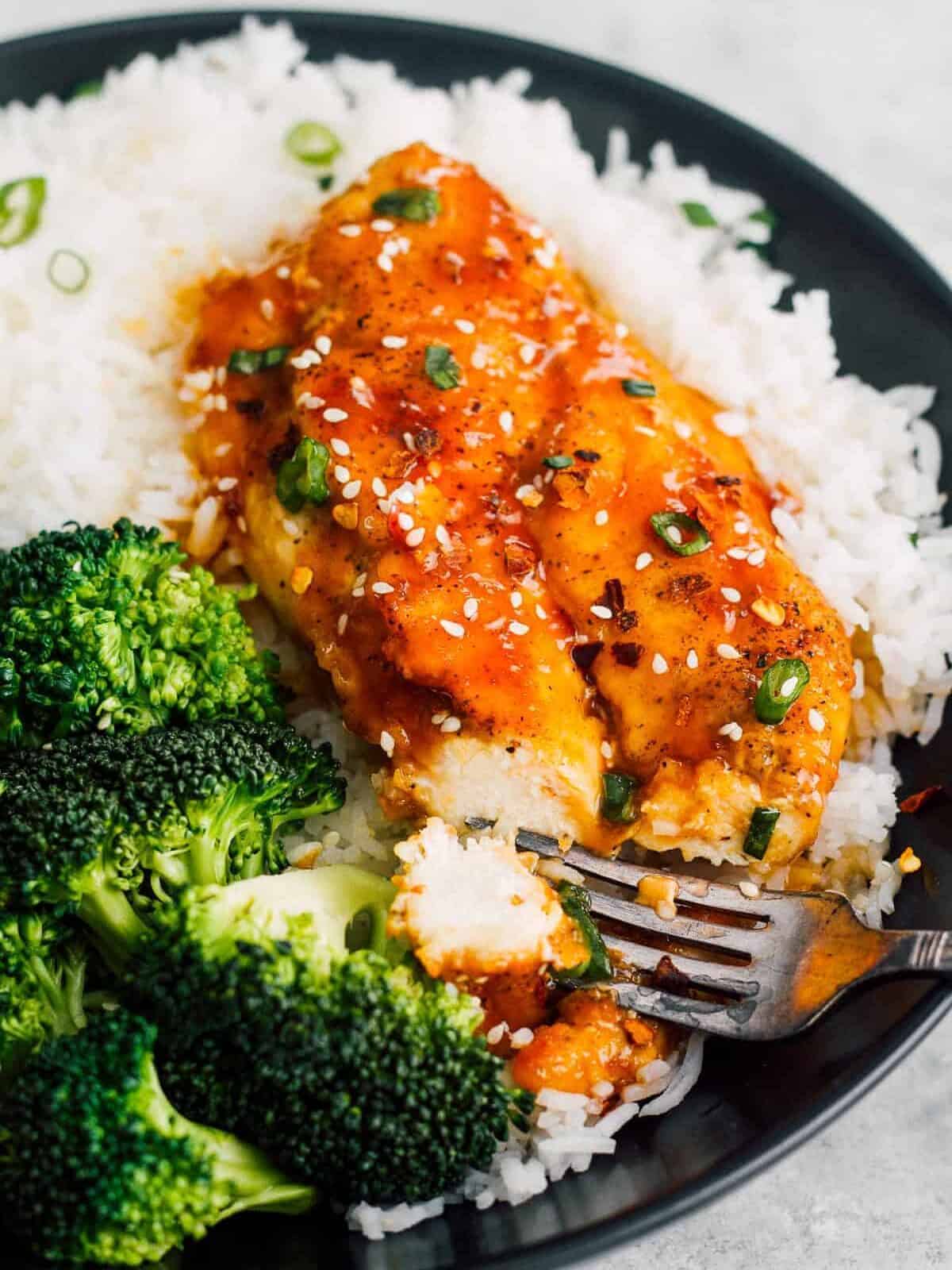 honey garlic chicken breast served with white rice and broccoli with fork
