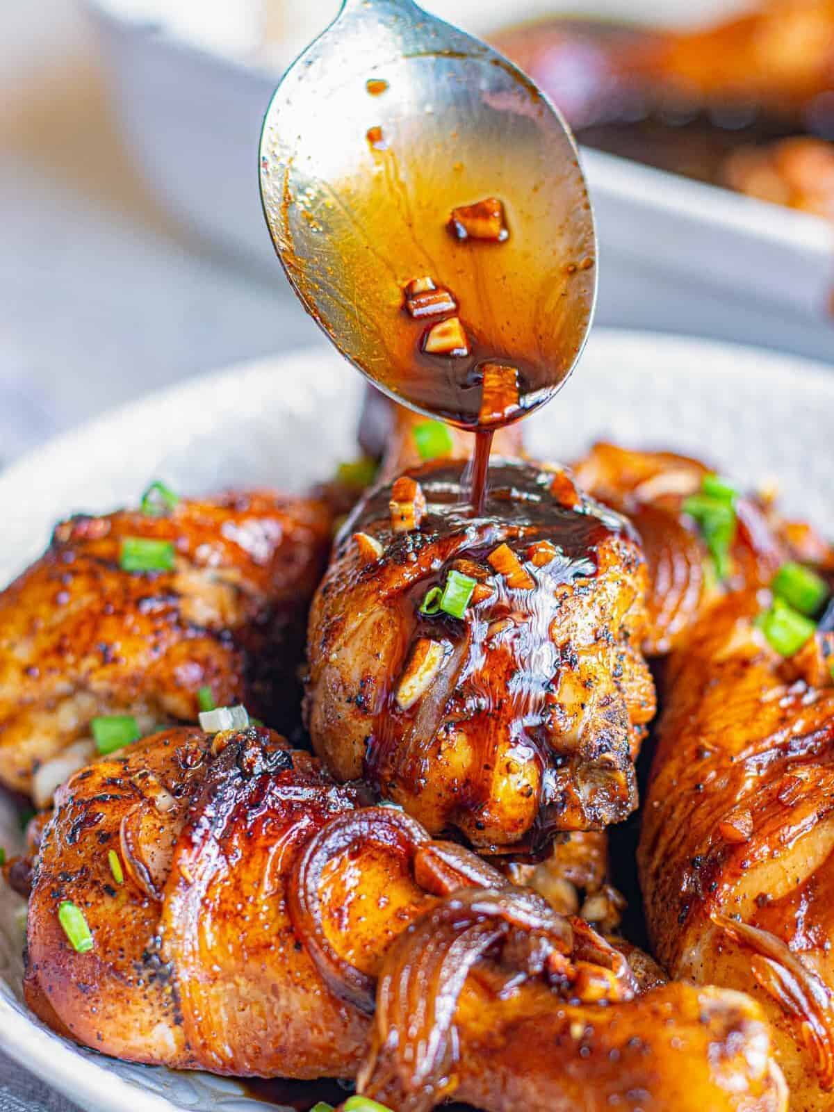 pouring honey soy sauce on chicken drumsticks
