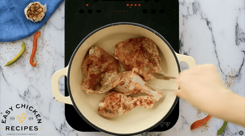 pieces of chicken in a dutch oven.