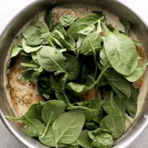 handful of fresh spinach on top of chicken.