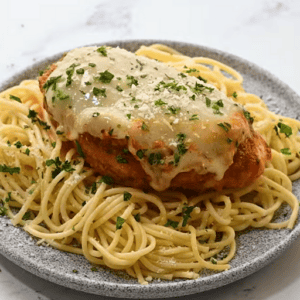 Crockpot chicken parmesan and spaghetti on a plate.