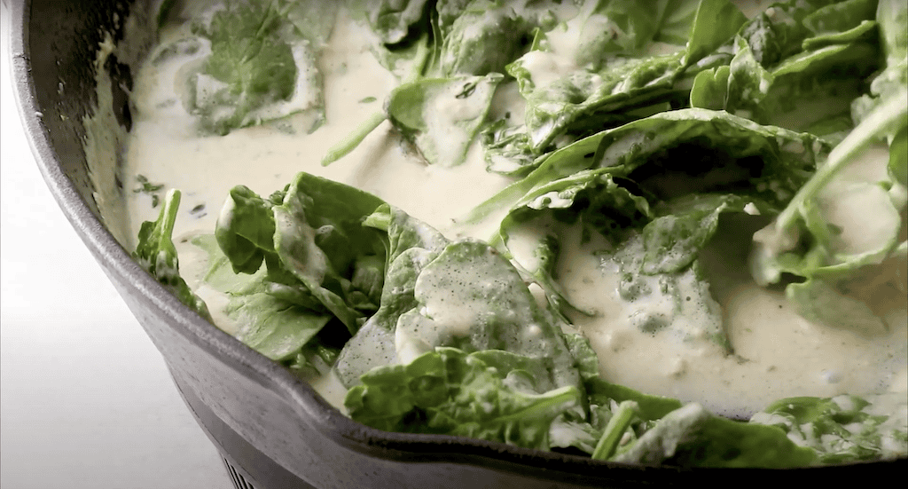 Spinach cooking in a creamy sauce.
